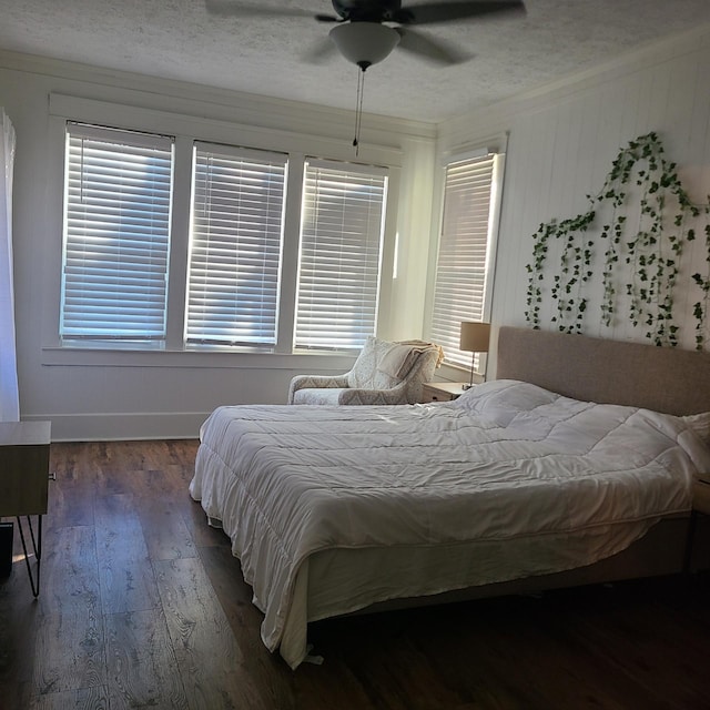 bedroom featuring ceiling fan, crown molding, dark wood-type flooring, and multiple windows