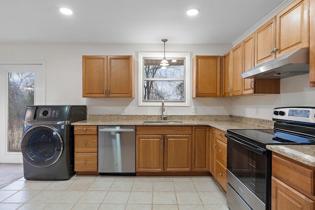 kitchen featuring light stone countertops, sink, washer / clothes dryer, pendant lighting, and appliances with stainless steel finishes