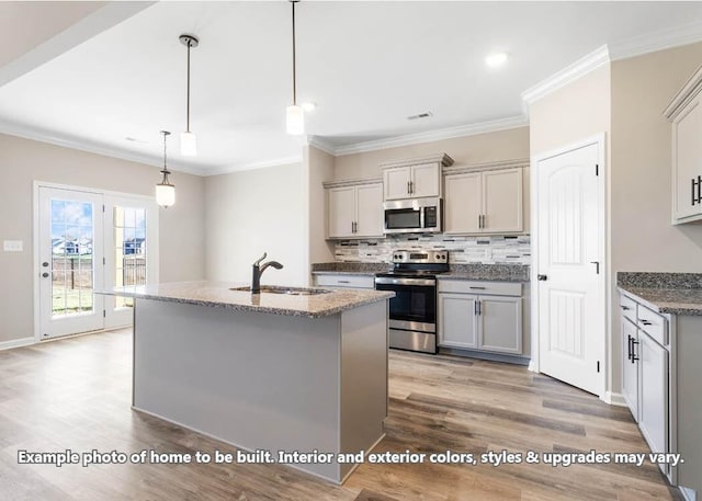 kitchen featuring gray cabinetry, sink, hanging light fixtures, stainless steel appliances, and a kitchen island with sink