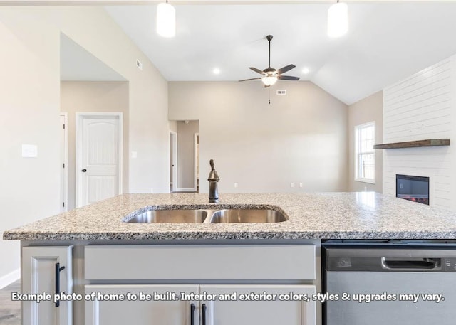 kitchen featuring stainless steel dishwasher, vaulted ceiling, ceiling fan, sink, and a fireplace