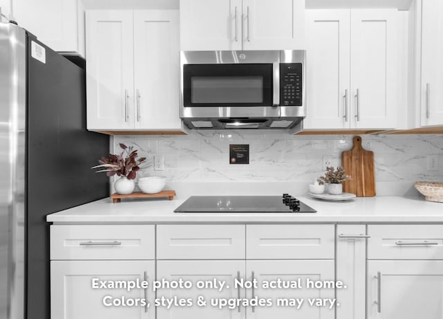 kitchen featuring tasteful backsplash, appliances with stainless steel finishes, and white cabinets