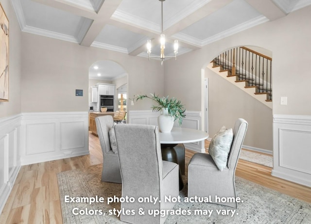 dining space with coffered ceiling, crown molding, a chandelier, beamed ceiling, and light hardwood / wood-style floors