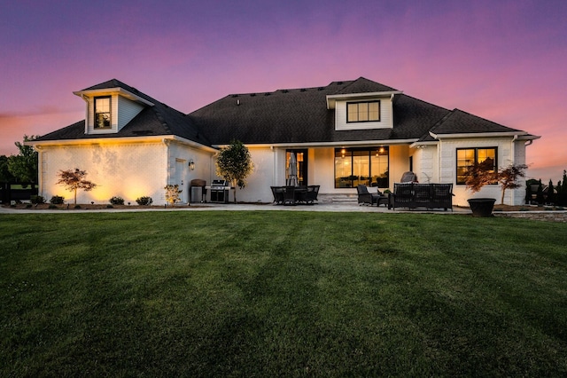 view of front facade with a lawn, a patio area, and an outdoor hangout area