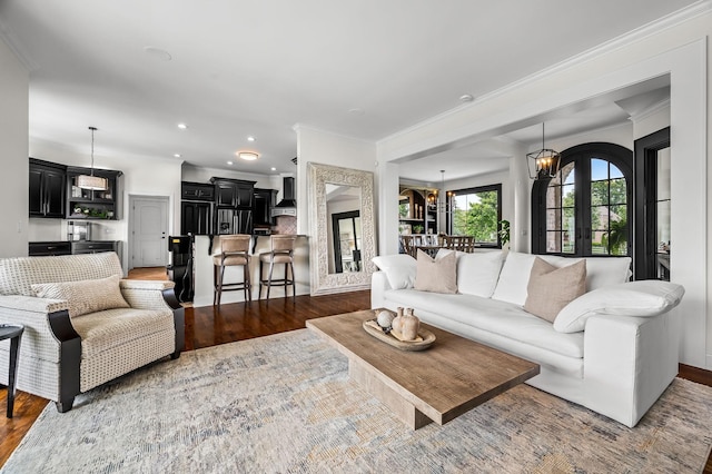 living room with french doors, ornamental molding, dark hardwood / wood-style floors, and an inviting chandelier