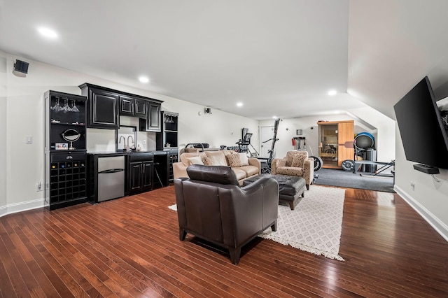 living room with vaulted ceiling, wet bar, and dark wood-type flooring