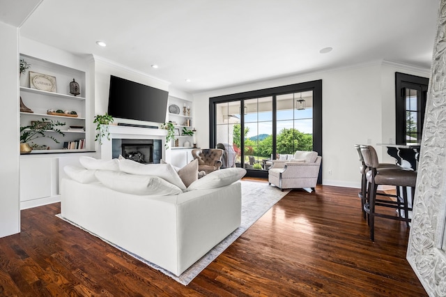 living room featuring built in shelves, dark hardwood / wood-style floors, and ornamental molding