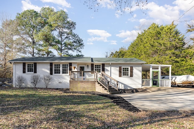 view of front of home with crawl space, an attached carport, concrete driveway, and brick siding