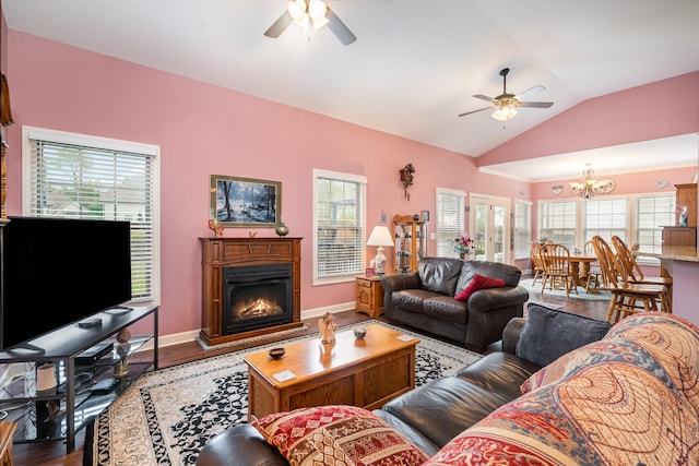 living room with hardwood / wood-style floors, ceiling fan with notable chandelier, and vaulted ceiling