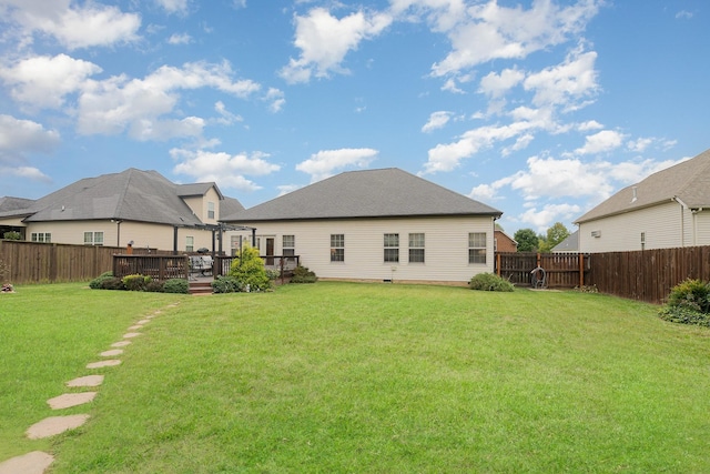 rear view of property with a lawn and a wooden deck