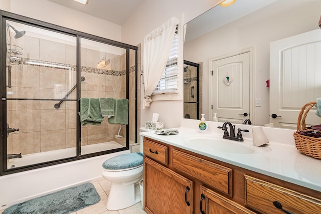 full bathroom featuring toilet, tile patterned flooring, vanity, and combined bath / shower with glass door