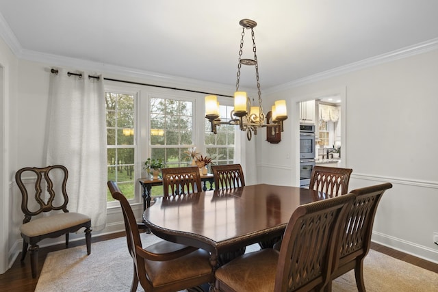 dining area featuring a chandelier, wood-type flooring, and crown molding