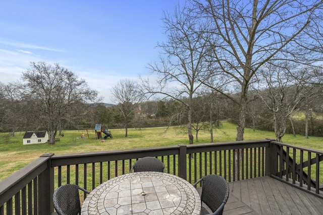 deck featuring a playground and a yard