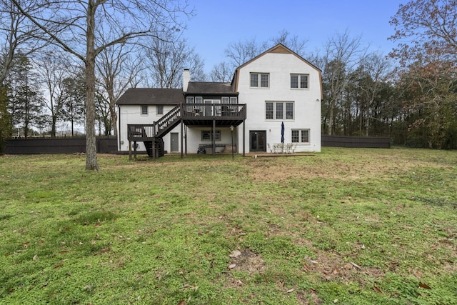 rear view of property featuring a yard and a deck