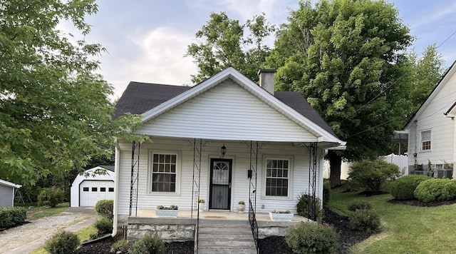 bungalow-style home featuring an outbuilding, a garage, and a front lawn