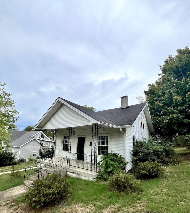 view of front of property featuring a chimney and a porch