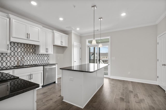 kitchen featuring white cabinets, stainless steel dishwasher, decorative light fixtures, and a kitchen island