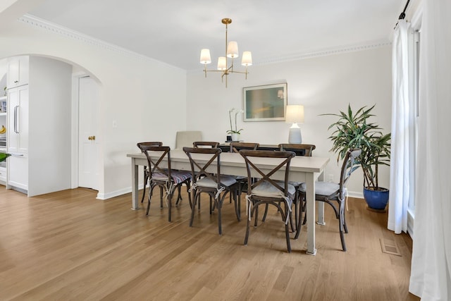 dining area featuring a chandelier, light hardwood / wood-style flooring, and ornamental molding