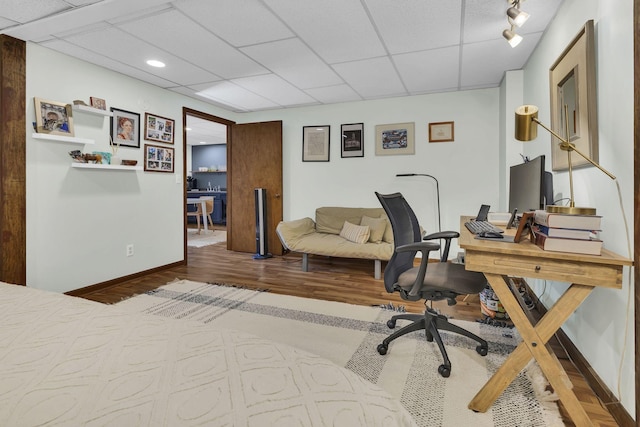 office space featuring hardwood / wood-style floors, rail lighting, and a drop ceiling