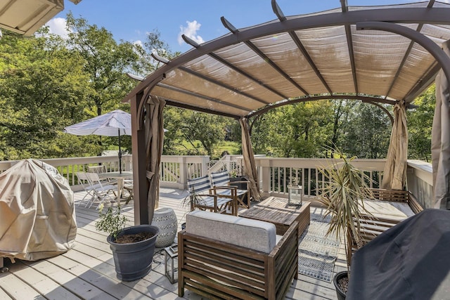 wooden deck featuring area for grilling and a pergola