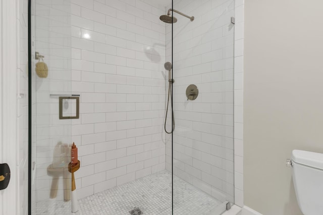 bathroom featuring toilet and tiled shower