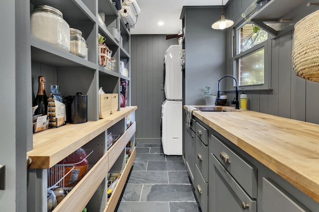 pantry with sink and stacked washer / drying machine