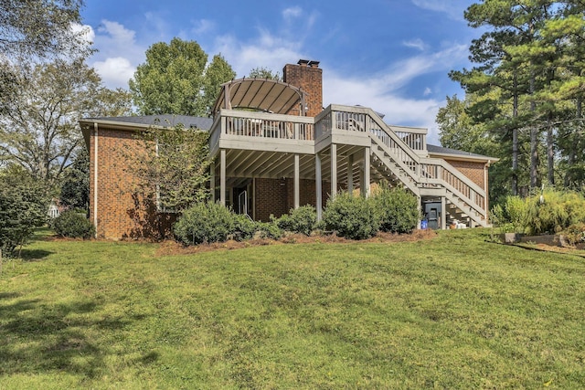 rear view of house featuring a yard and a wooden deck