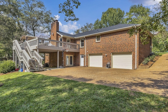 rear view of house with a garage, a lawn, and a wooden deck