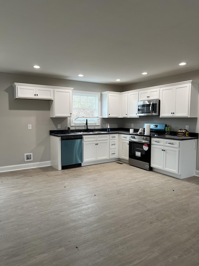 kitchen featuring white cabinets, appliances with stainless steel finishes, and light wood-type flooring