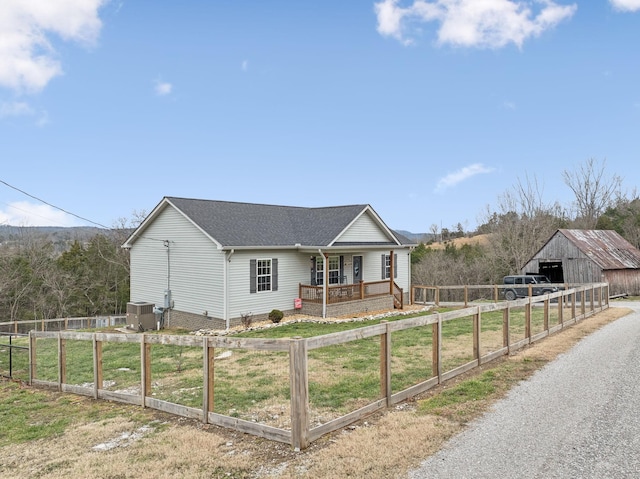 view of front of house featuring an outbuilding, covered porch, and central air condition unit