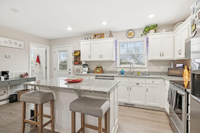 kitchen featuring white cabinetry, sink, a kitchen island, and appliances with stainless steel finishes