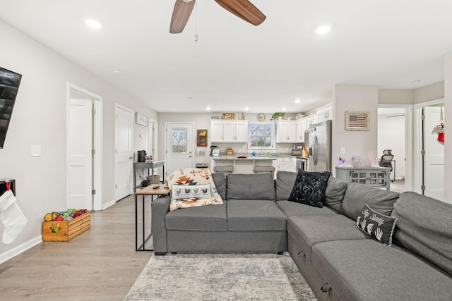 living room with ceiling fan and light wood-type flooring