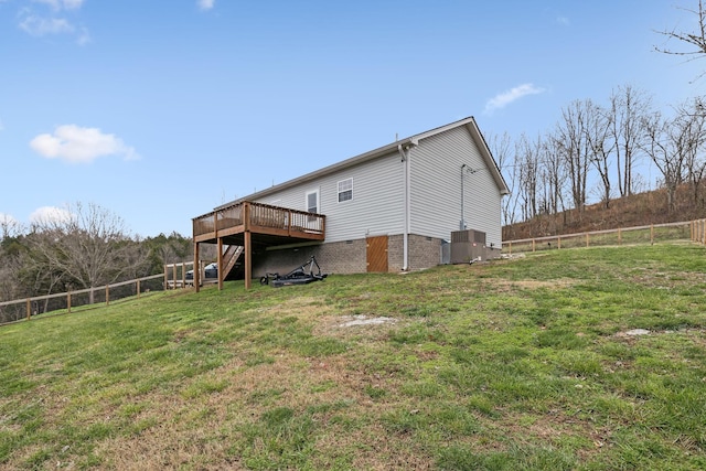 rear view of house featuring a lawn, cooling unit, and a deck