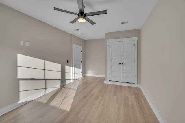 empty room with ceiling fan and light hardwood / wood-style floors