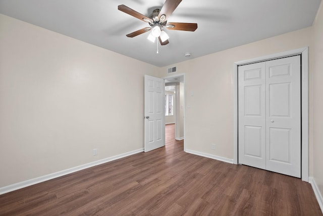 unfurnished bedroom with a closet, ceiling fan, and dark hardwood / wood-style flooring