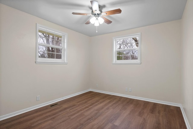 spare room featuring ceiling fan and dark wood-type flooring