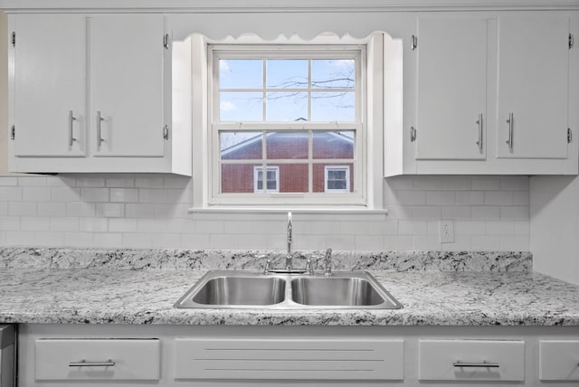 kitchen with tasteful backsplash, sink, and white cabinets