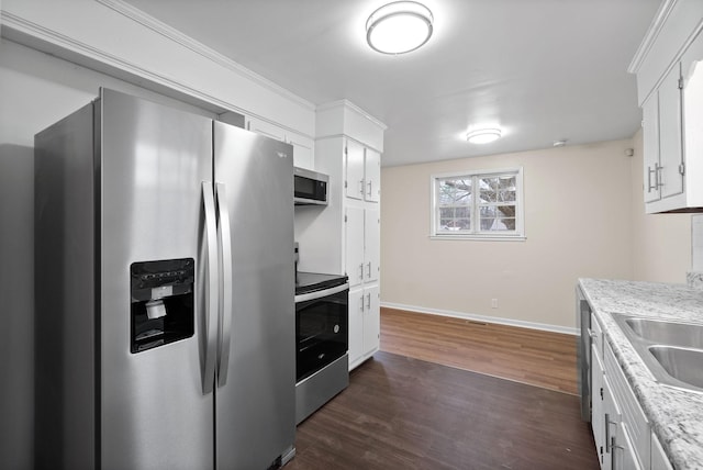 kitchen with white cabinets, sink, dark hardwood / wood-style floors, light stone countertops, and appliances with stainless steel finishes