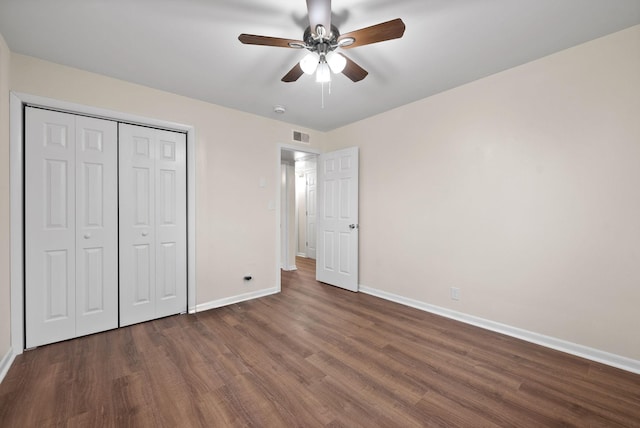 unfurnished bedroom featuring ceiling fan, dark hardwood / wood-style flooring, and a closet