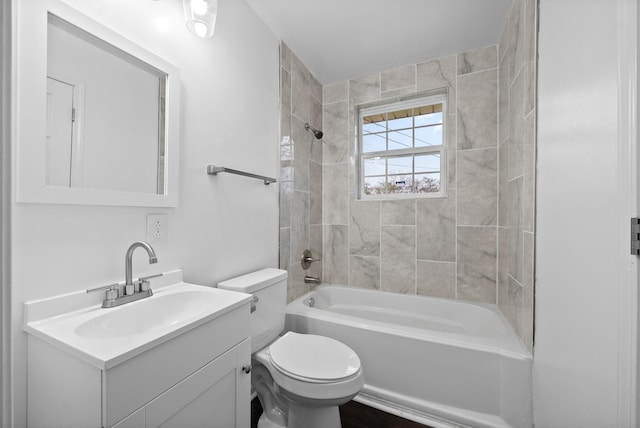 full bathroom with vanity, tiled shower / bath combo, and toilet