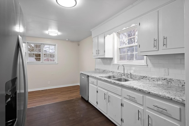 kitchen featuring backsplash, white cabinetry, sink, and appliances with stainless steel finishes