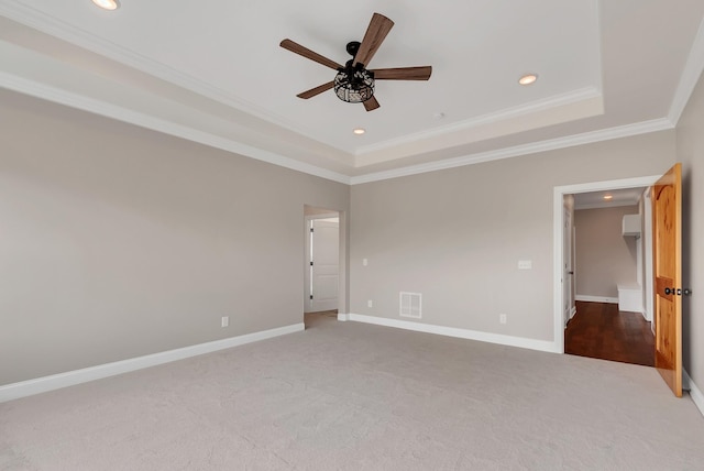 unfurnished bedroom with ceiling fan, a tray ceiling, crown molding, and carpet flooring