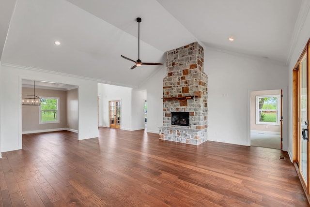 unfurnished living room with a fireplace, dark wood-type flooring, ornamental molding, high vaulted ceiling, and ceiling fan with notable chandelier