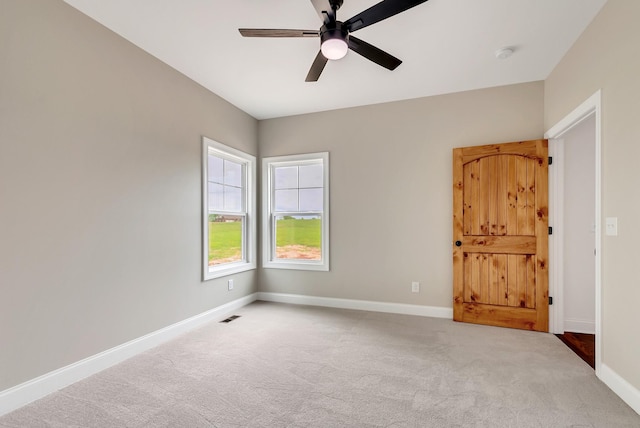 spare room with ceiling fan and light colored carpet