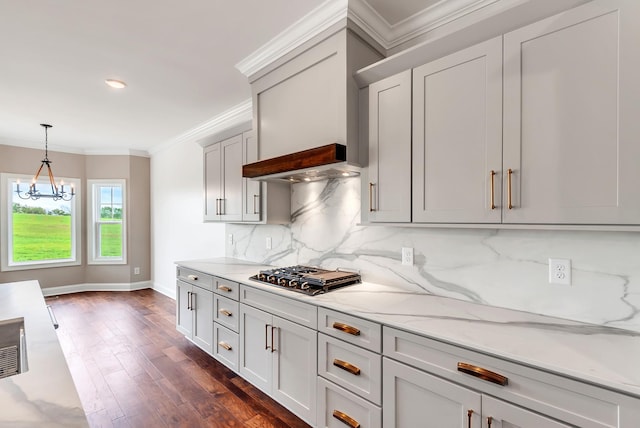 kitchen featuring decorative light fixtures, backsplash, stainless steel gas stovetop, light stone countertops, and dark hardwood / wood-style flooring