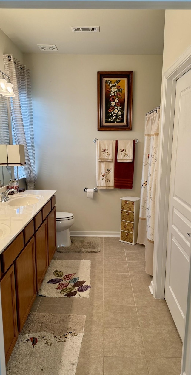 bathroom featuring tile patterned flooring, vanity, and toilet