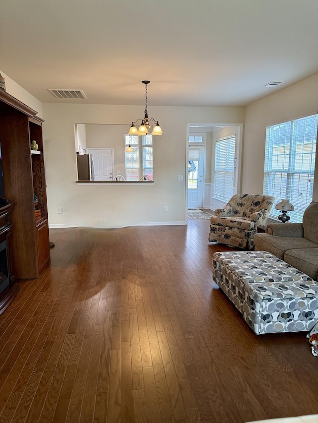 living room featuring dark hardwood / wood-style floors and an inviting chandelier