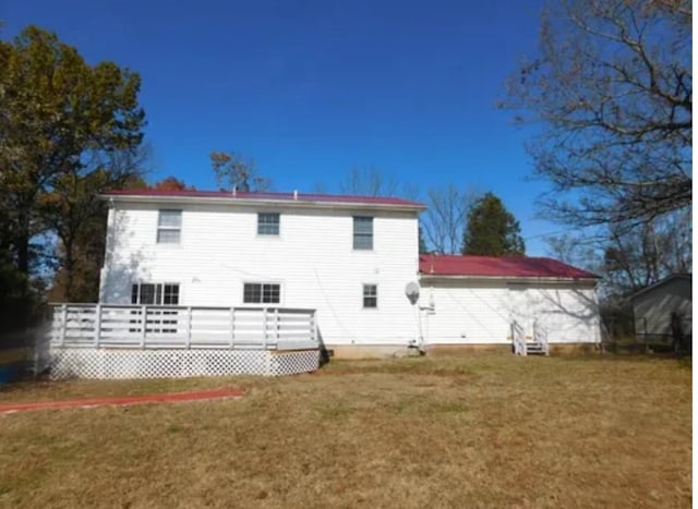 back of property featuring a lawn and a wooden deck