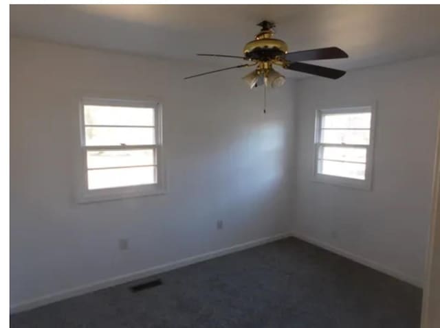 carpeted spare room featuring ceiling fan