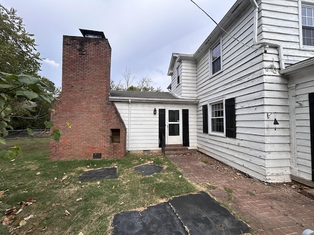 back of property featuring a lawn