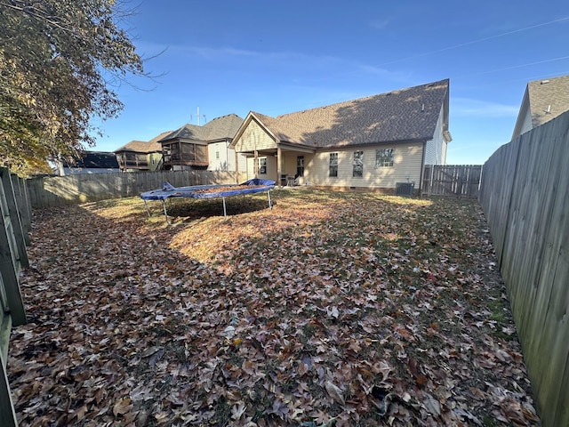 back of house featuring a trampoline and central AC unit